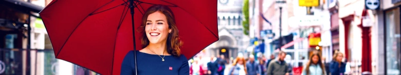 girl in blue dress holding big red umbrella