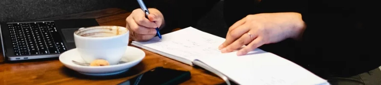 Person taking notes in a cafe