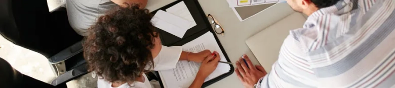 Overhead view of two professionals reviewing documents at a business meeting.