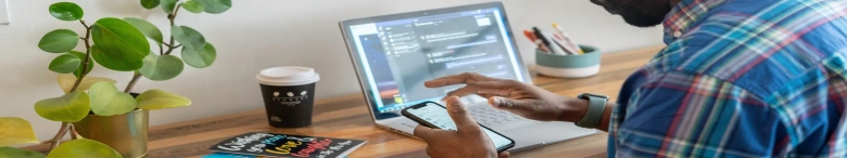 man using a laptop and a phone