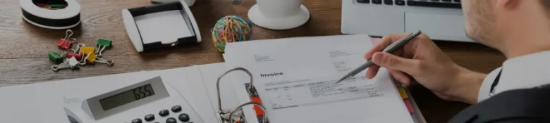 Person in a suit writing at a desk 